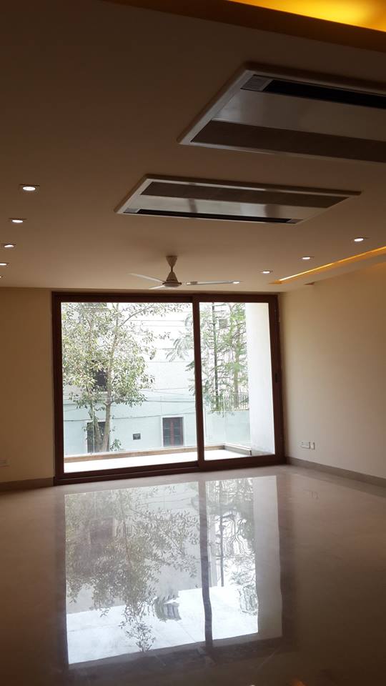 Polished marble living room with floor-to-ceiling windows and recessed cove lighting — GK I Residence, Greater Kailash I, New Delhi